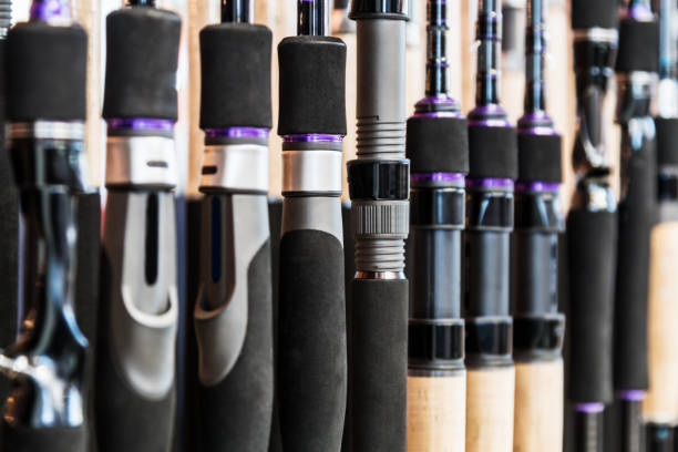 forms of fishing rods and spinning rods on the counter in the store stock photo