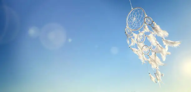 Photo of Dream catcher on blue sky background with copy space