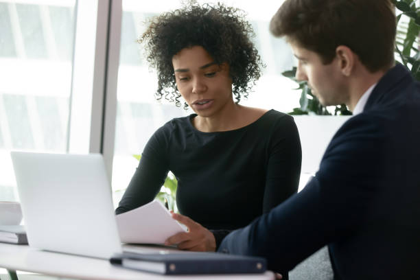 istock Multiracial colleagues analyzing financial report during meeting in office 1226412410