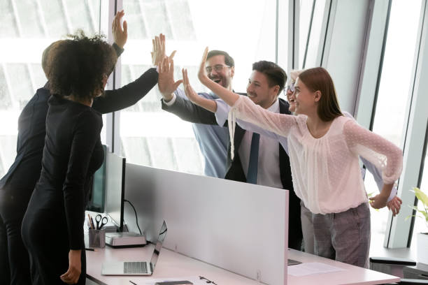 istock Group of diverse coworkers giving high five share common success 1226412484