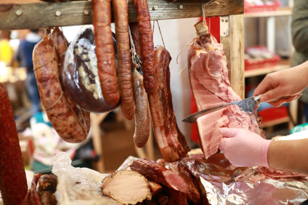 istock Person cuts slice of ham 1226413230