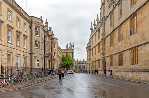Tourists crossing the road outside the Bodleian Library and All Souls College at the university of Oxford. Oxford, Oxfordshire, England, UK
