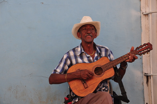 So much of Cuban life takes place on the city streets: negotiating with ambulant vendors, gossiping and board games with neighbors, playing music for passersby, etc. Here, one of the band members plays the guitar. Photos taken in Trinidad in January 2017.
