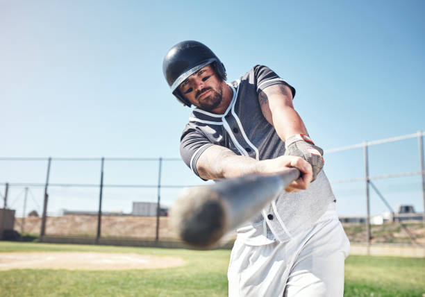 Knock it right out of the park Shot of a young man swinging his bat at a baseball game baseball hitter stock pictures, royalty-free photos & images