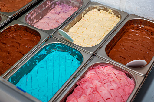 Different flavored colorful Ice cream serving counter with many scoopable flavors.Assorted Flavors of Icecream in the counter