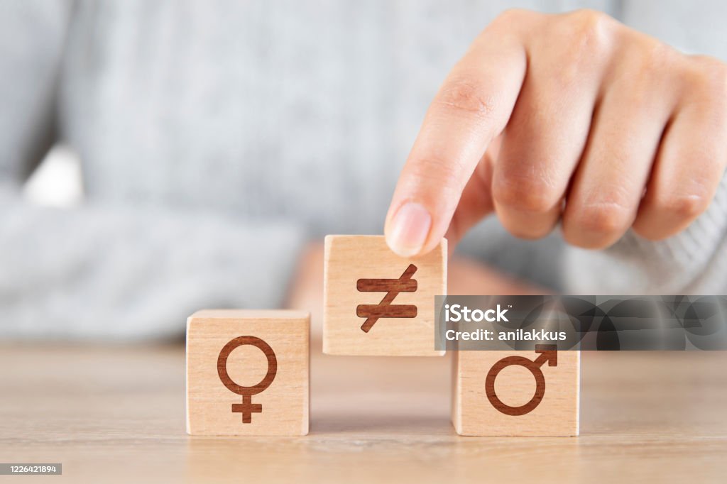 Gender Inequality Female hand putting not equal symbol between men and woman icons Imbalance Stock Photo