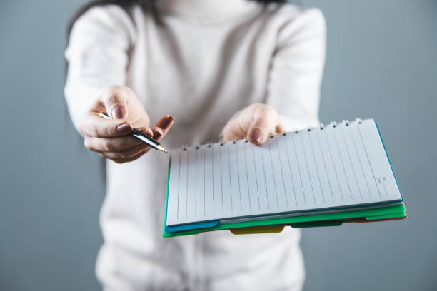 istock woman hand holding pen and notepad 1226423348