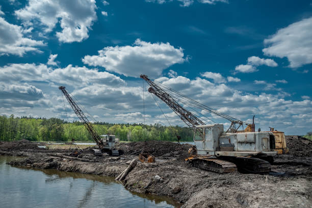 istock Excavators on a dirt road near a lake 1226424554