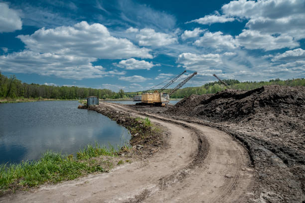 istock Excavator on a dirt road near a lake 1226424561