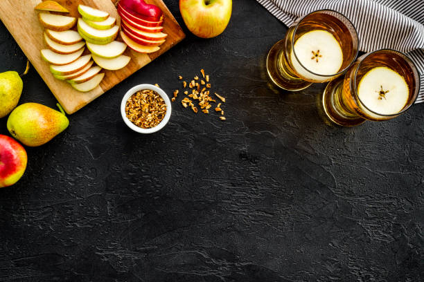 istock Glasses of beer with apple and peer on black table top view copy space 1226424674