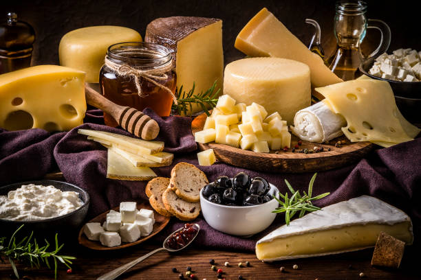 various kinds of cheeses on a rustic wooden table - milk old fashioned retro revival still life imagens e fotografias de stock