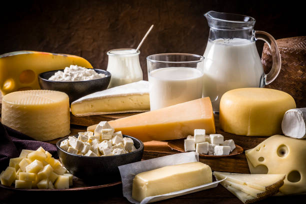 varios tipos de productos lácteos en una mesa de madera rústica - dairy product fotografías e imágenes de stock