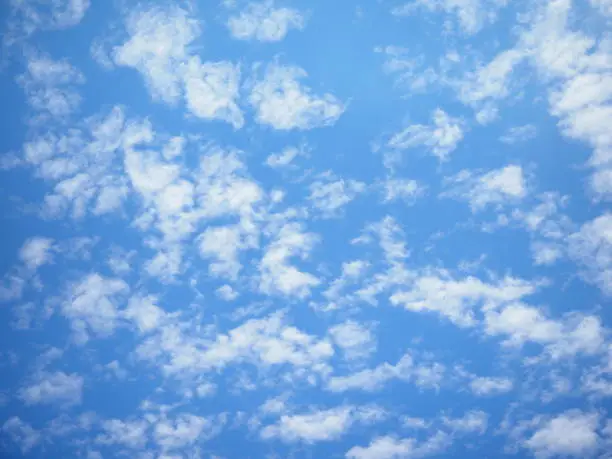 white fluffy clouds on bright blue sky background, many small clouds in the sky