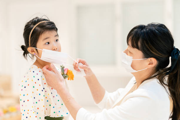 istock Mother putting protective mask on her daughter`s face 1226427613