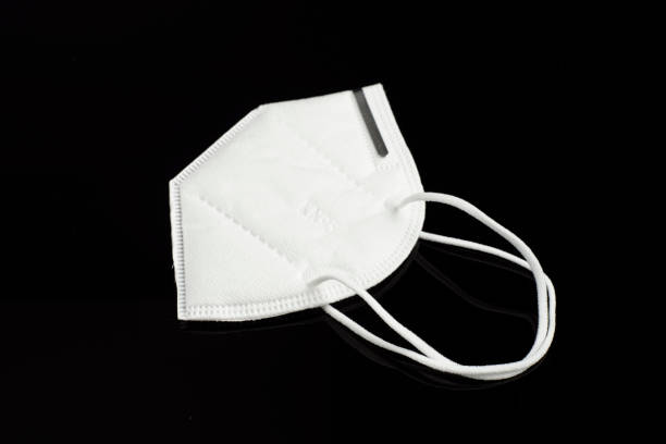 istock White face mask on black background. Protector to prevent contagion. 1226428798