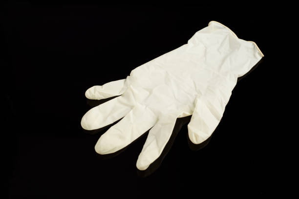 istock Beige latex gloves, on black background. Protector to prevent contagion. 1226428811