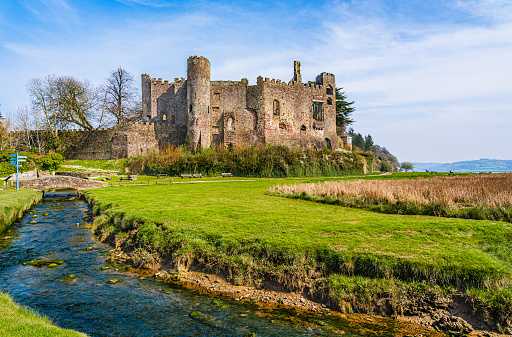 Laugharne, Pembrokeshire, Wales, UK: Ruins of the medieval castle at Laugharne by a stream of water