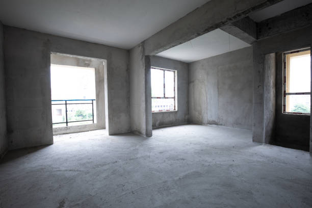 Building construction site of modern wooden house. Workers standing on ladders. Craftsmen working in living room
