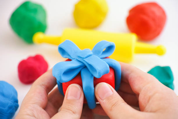 istock Child holding play clay gift wrapped with blue ribbon 1226435209