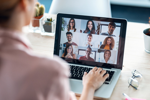 female employee speaking on video call with diverse colleagues on online briefing with laptop