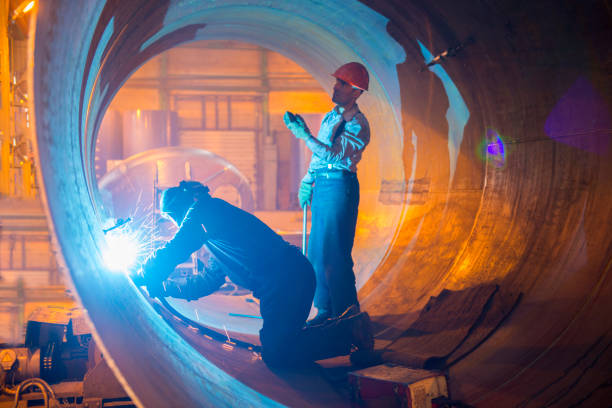 два сварщика работают в трубе для нефтепровода. - welding welder pipeline manufacturing occupation стоковые фото и изображения