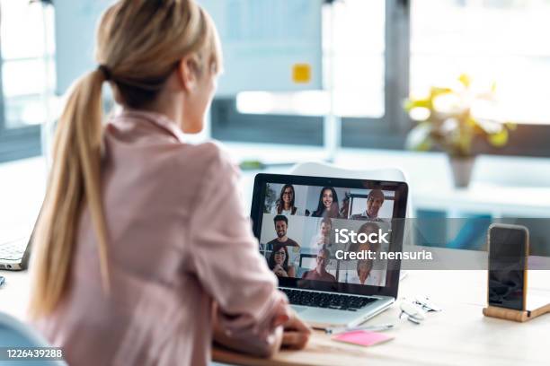 Dipendente Donna Che Parla In Videochiamata Con Diversi Colleghi In Briefing Online Con Laptop A Casa - Fotografie stock e altre immagini di Riunione