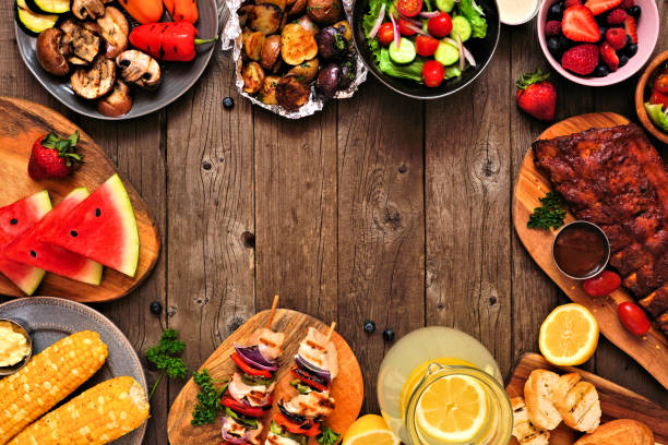istock Summer BBQ or picnic food frame over a rustic wood background, top down view with copy space 1226450119