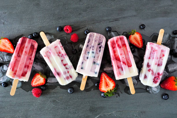 istock Assorted berry fruit yogurt popsicles, top view in a row over slate 1226450407