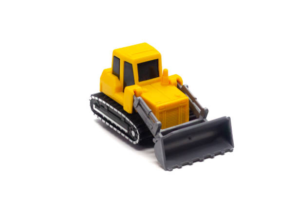 dozer amarelo laranja de brinquedo pequeno isolado no fundo branco - wheel tractor scraper - fotografias e filmes do acervo