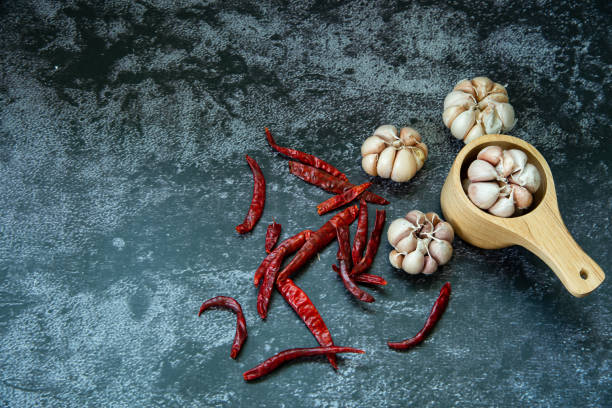 poivron chaud séché rouge et ail dans la cuillère en bois sur fond de texture grise, le piment et l’ail sont ingedient de nourriture thaïlandaise - ingedient photos et images de collection