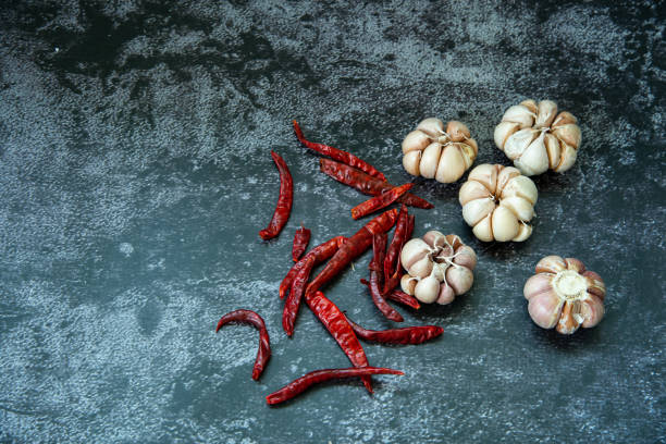 красный сушеный острый перец чили и чеснок на сером фоне текстуры, чили и чеснок являются ingedient тайской кухни - ingedient стоковые фото и изображения