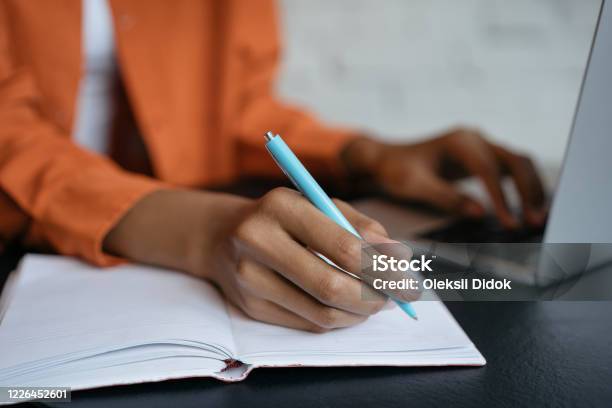 Closeup Shot Of Student Hand Holding Pen And Writing In Notebook Working At Home Elearning Stock Photo - Download Image Now