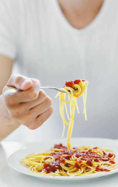istock Man eating tasty spaghetti with fork 1226453955