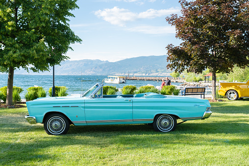 Penticton, British Columbia/Canada - June 21, 2019: vintage convertible car parked by Okanagan Lake during the Peach City Beach Cruise. This annual car show runs every June by Okanagan Lake, and is one of the largest car shows in North America.