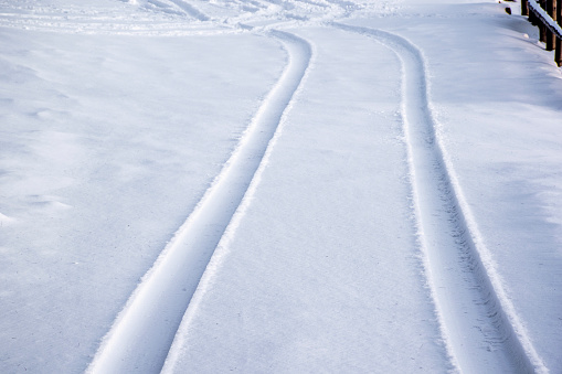 car tracks imprinted on fresh snow on the Asiago plateau in the province of Vicenza, Italy