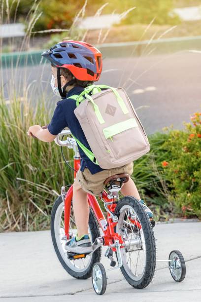istock Little boy riding a bicycle wearing a protective mask 1226463216