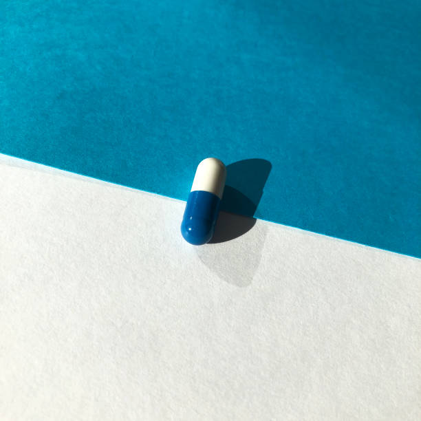 istock Blue and white pills on blue background. 1226463235