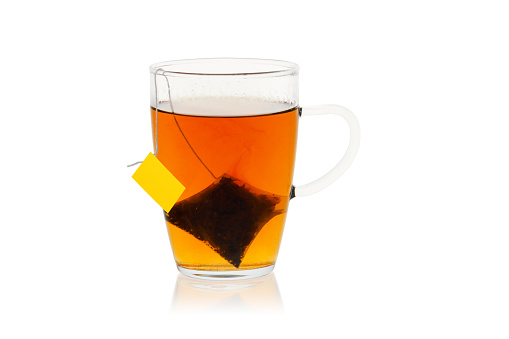 Glass of tea with a bag isolated on white background