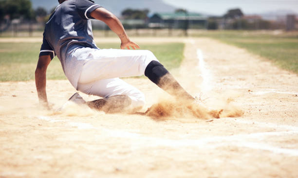 You can't win without a little dust Shot of a young man reaching base during a baseball match baseball sport stock pictures, royalty-free photos & images