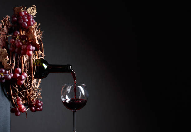 istock Red wine pouring from a bottle into a glass. 1226467012