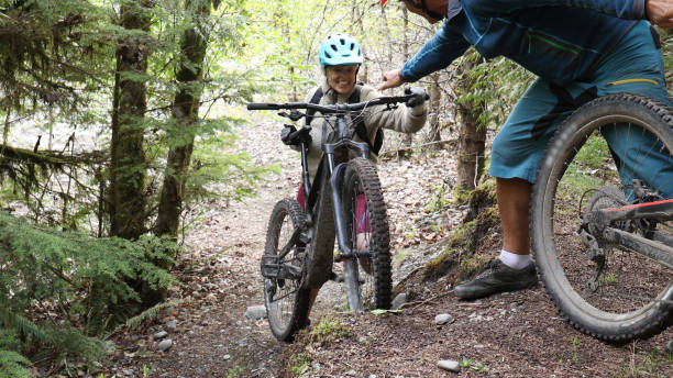 istock Man helps push mountain e-bikes up steep forested trail 1226467582