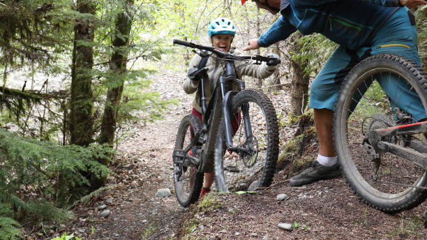 istock Man helps push mountain e-bikes up steep forested trail 1226467583