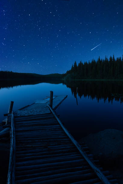 istock Vertical Landscape of A Pier and Starry Sky With A Comet 1226467899