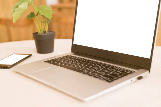 istock A workplace in a bright kitchen during quarantine. Laptop with place for text. Telework. freelance. flowerpot, phone and cup on the table.Copy space. 1226470676