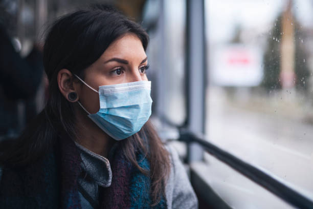 istock Woman With Protective Face Mask Looking Through The Window. 1226472683