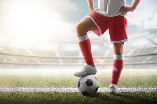 Soccer closeup. Leg of soccer player on the ball. Soccer background. Day stadium.