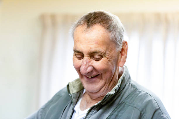 istock Portrait of laughing senior man, looking down, background with copy space 1226476086