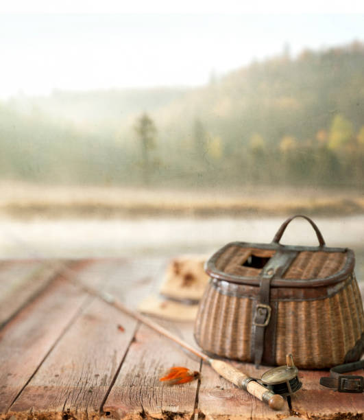 Vintage Wicker Creel and Fly Fishing Equipment Set against a Natural Scenic Background