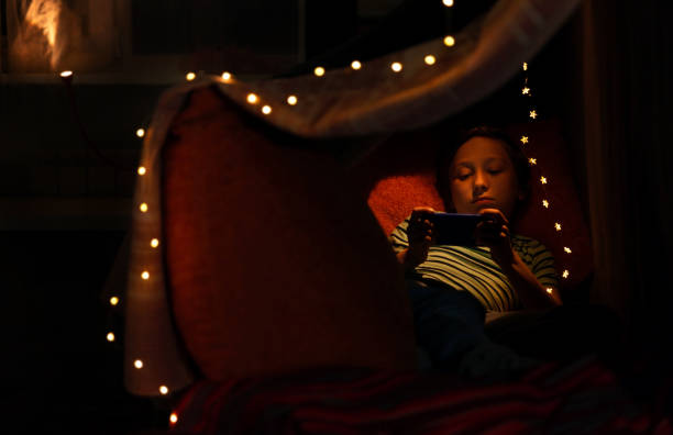 istock Kid boy watching movie on smart phone in bed 1226476996