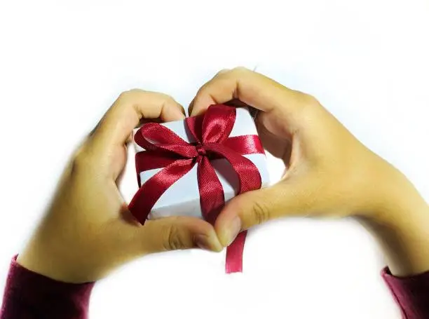 hands holding a red-ribbon gift box